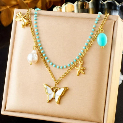 Bijoux Charm Double collier à charms doré avec papillon blanc et perle.